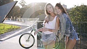 Gorgeous joyful sexy girls in fashion clothes posing on camera with sincerely smiles on the city background