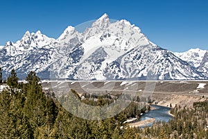 Gorgeous landscape in Grand Teton National Park with snow covered mountains and the Snake river in the foreground.