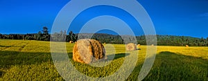 Gorgeous landscape of a stack of hay in rural areas during fall season with warmest colors and attractive composition.