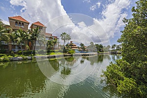 Gorgeous landscape view of hotel grounds with green trees courses and lake against blue sky with white clouds background.