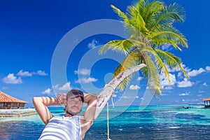 Gorgeous Man Resting on Beach Palm Tree