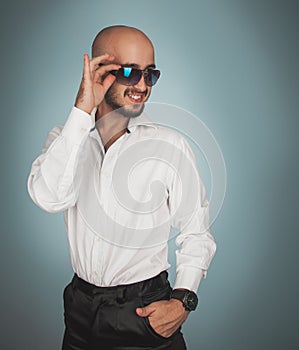 Gorgeous man in sunglasses and white shirt smiling