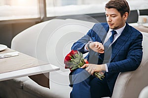 Gorgeous man in tuxedo waiting for a woman, on a date