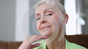 Gorgeous middle aged Caucasian woman flirting looking at camera smiling. Close-up portrait of confident beautiful slim