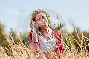 Gorgeous middle aged woman listening to music outdoors