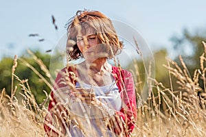 Gorgeous middle aged woman wandering in dry high meadows