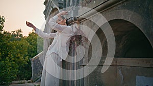 Gorgeous model posing ancient building leaning old wall. Woman posturing castle