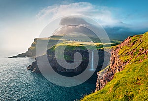 Gorgeous morning scene of Mulafossur Waterfall. Amazinf summer view of Vagar island, Faroe Islands, Denmark, Europe. Beauty of nat