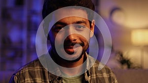 Gorgeous portrait of attractive confident Arabian man with toothy smile looking at camera in modern living room