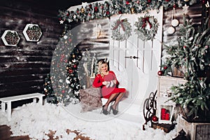 Gorgeous pregancy woman in red holding socks on stomach. Christmas.