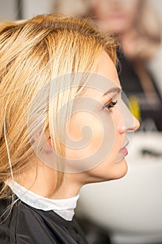 Gorgeous profile of caucasian beauty blonde woman with beautiful hairstyle over hair salon background.