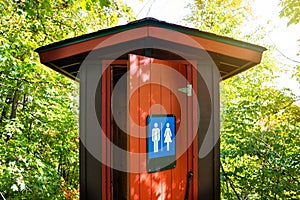 Gorgeous red and brown public toilet in the middle of the woods, Gatineau Park ,Quebec, Canada