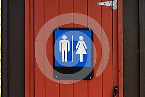 Gorgeous red and brown public toilet sign in the middle of the woods, Gatineau Park ,Quebec, Canada