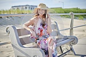 Gorgeous redhead woman poses in print dress at shore