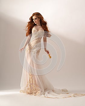 Gorgeous redhead woman posing in fashion long dress