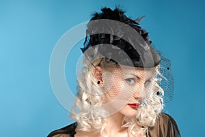 Gorgeous retro girl in forties hat with feathers
