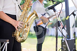 Gorgeous saxophonist lady is playing saxophone in wedding ceremony. musician woman. attractive woman and music instrument .