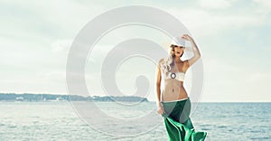 Gorgeous, girl wearing hat, bikini and green silk on the be