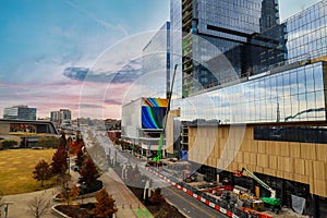 A gorgeous shot of the autumn landscape in the city with glass buildings with color murals and a green construction crane