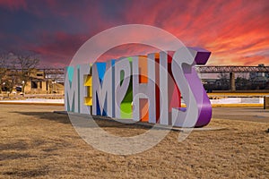 A gorgeous shot of the colorful Memphis sign with gorgeous blue sky and powerful clouds at sunset with yellow winter grass