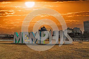 A gorgeous shot of the colorful Memphis sign with gorgeous blue sky and powerful clouds at sunset with yellow winter grass