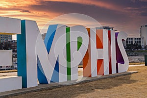 A gorgeous shot of the colorful Memphis sign with gorgeous blue sky and powerful clouds with yellow winter grass and skyscrapers