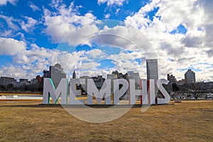 A gorgeous shot of the colorful Memphis sign with gorgeous blue sky and powerful clouds with yellow winter grass and skyscrapers