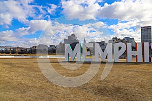 A gorgeous shot of the colorful Memphis sign with gorgeous blue sky and powerful clouds with yellow winter grass and skyscrapers