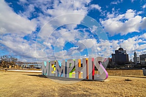 A gorgeous shot of the colorful Memphis sign with gorgeous blue sky and powerful clouds with yellow winter grass and skyscrapers