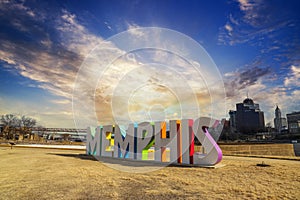 A gorgeous shot of the colorful Memphis sign with gorgeous blue sky and powerful clouds with yellow winter grass and skyscrapers