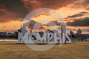 A gorgeous shot of the colorful Memphis sign with gorgeous red sky and powerful clouds at sunset with yellow winter grass