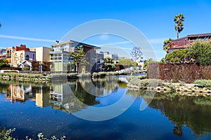 A gorgeous shot of the lush green waters of the canal with colorful boats and lush green trees and plants reflecting off the water