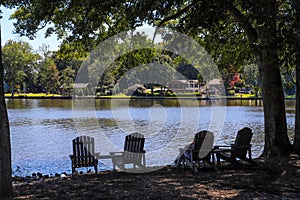 A gorgeous shot of people relaxing on the banks of the lake in lawn chairs with simmering lake water