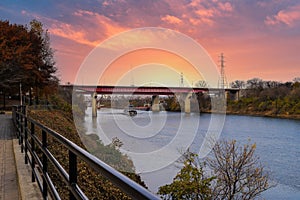 A gorgeous shot of the rippling waters of the Cumberland river with a white tug boat sailing under a red metal bridge