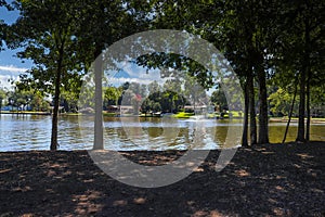 A gorgeous shot of the still blue waters of the lake with water fountain in the lake with lake front homes