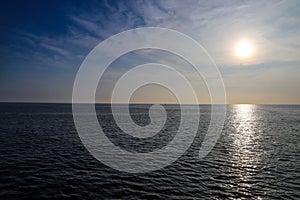 A gorgeous shot of vast blue rippling ocean water at sunset with blue sky and clouds at sunset at Surfers Point at Seaside Park