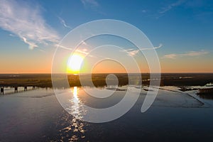 A gorgeous shot of the vast flowing water of the Mississippi river with a stunning blue, yellow and red sunset set in the sky