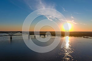 A gorgeous shot of the vast flowing water of the Mississippi river with a stunning blue, yellow and red sunset in the sky