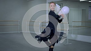 Gorgeous slim young ballerina performing pirouette with balloons smiling looking at camera. Portrait of confident