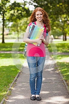 Gorgeous smiling student carrying notebooks