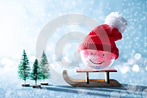 Gorgeous snowman christmas bauble on Santas sleigh. Miniature Christmas winter wonderland. Xmas greeting card.