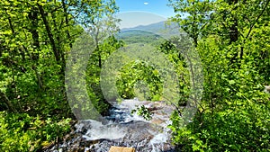 a gorgeous spring landscape with a flowing waterfall and rocks, lush green trees, grass and plants at Amicalola Falls State Park