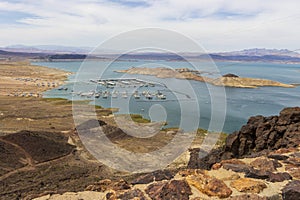 a gorgeous spring landscape at Lake Mead with vast blue water and majestic mountain ranges and boats and yachts docked