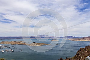 a gorgeous spring landscape at Lake Mead with vast blue water and majestic mountain ranges and boats and yachts docked