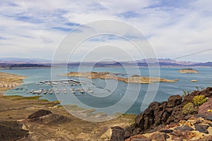 a gorgeous spring landscape at Lake Mead with vast blue water and majestic mountain ranges and boats and yachts docked