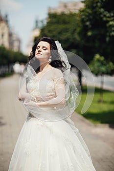 Gorgeous stylish blonde bride in vintage white dress walking in