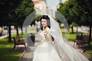 Gorgeous stylish bride in vintage white dress walking in