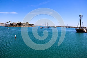 A gorgeous summer day at the harbor with boats and yachts docked in vast deep blue ocean water