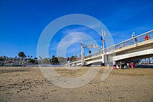 A gorgeous summer landscape at the Belmont Veterans Memorial Pier with blue ocean water and waves rolling into the beach