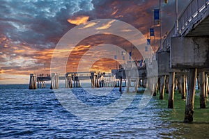 A gorgeous summer landscape at the Belmont Veterans Memorial Pier with blue ocean water and waves rolling into the beach